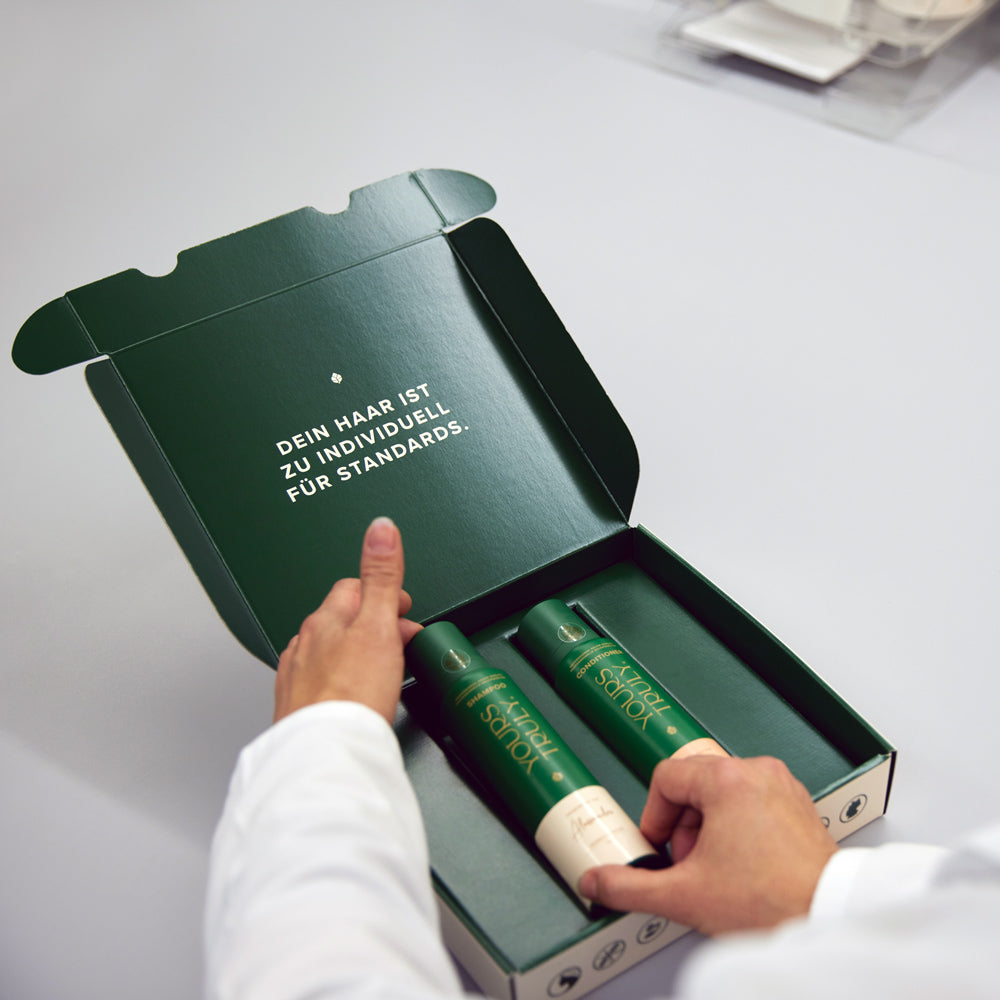person-hält-grüne-box-mit-yours-truly-shampoo-und-conditioner-und-aufdruck-dein-haar-ist-zu-individuell-für-standards