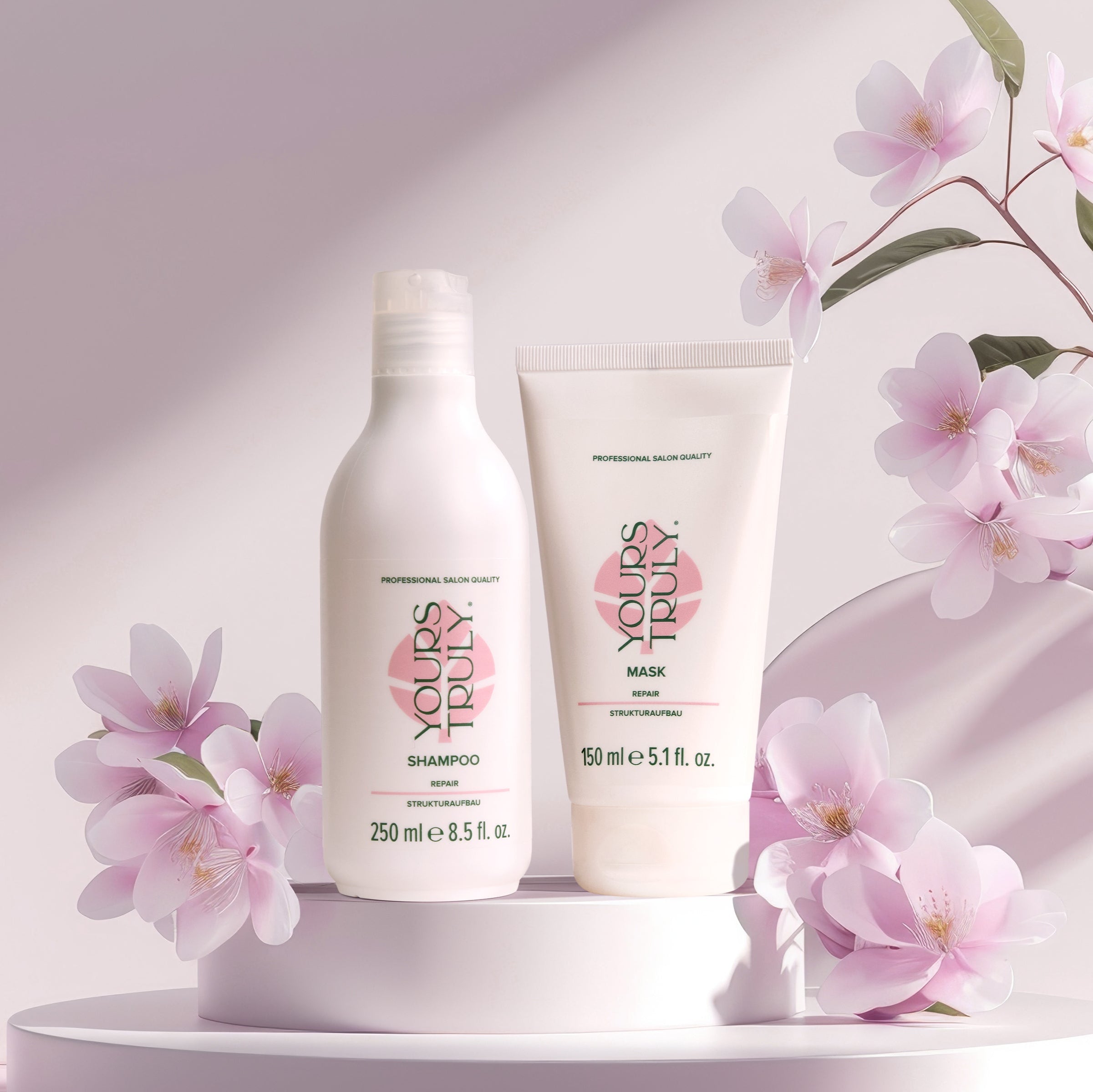 yours-truly-repair-shampoo-und-repair-maske-in-weißen-gebinden-auf-podest-mit-rosa-blüten-und-sanftem-rosa-hintergrund